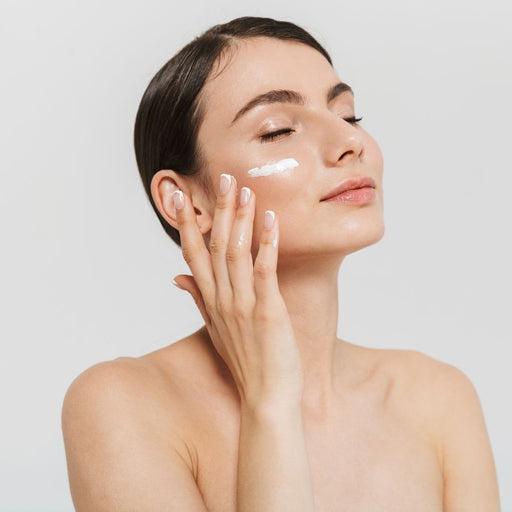 Model applying dry skin skincare on healthy skin with white background 